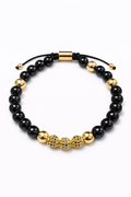 Pulsera negra con detalles dorados